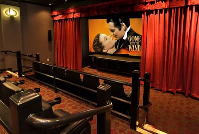 Interior of a movie theater with a screen playing a classic film