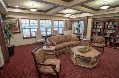 Common area seating with bookshelves and large windows