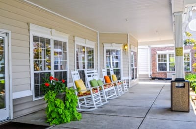 Outdoor seating area with rocking chairs and flower pots