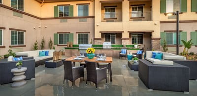 Stylish outdoor seating area with BBQ grill and greenery