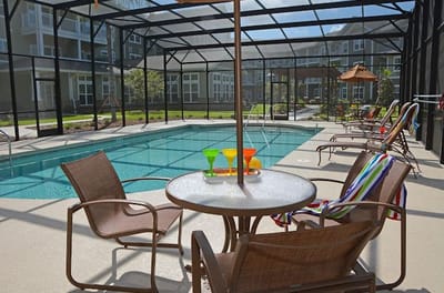 Swimming pool area with lounge chairs and tables