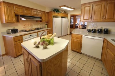 Bright kitchen area with wood cabinetry and appliances