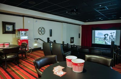Interior view of a movie theater room with seating and a screen