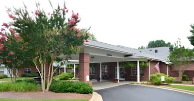 Entrance of a senior living facility with landscaped gardens