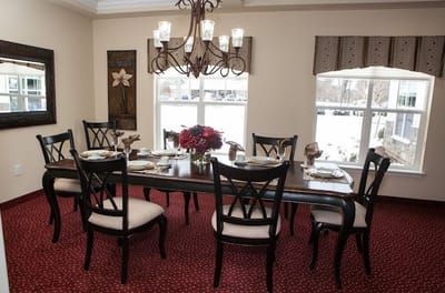 Brightly lit dining room with a large table and chairs