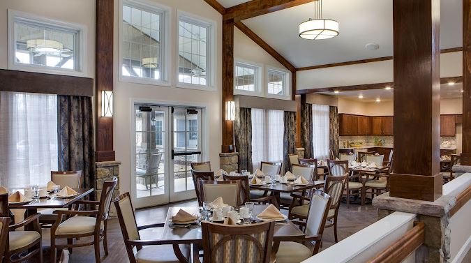 Bright dining room set for a meal with large windows