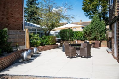 Outdoor patio area with seating and greenery