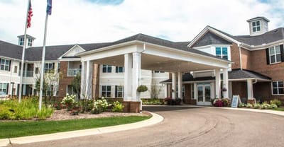 Front entrance of a senior living facility with flower beds