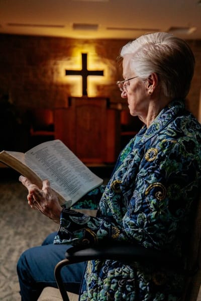 A resident reading a Bible in a serene room