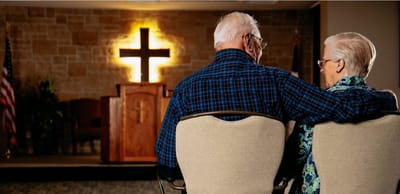Senior couple sitting in front of a chapel