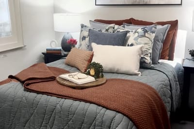 Cozy bedroom setup with decorative bedding and lamp