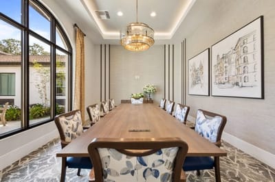 A modern dining room with a large table and elegant decor