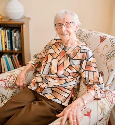 Resident smiling in a cozy armchair