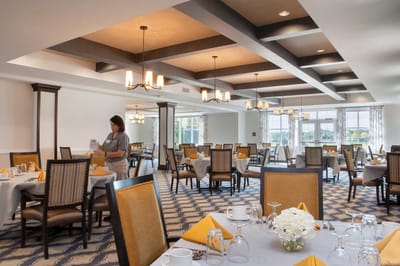 Dining room set for a meal with a staff member attending