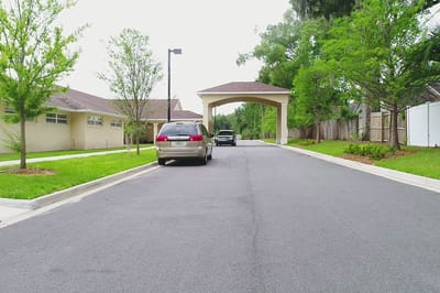 Entrance view with vehicles in a tree-lined driveway