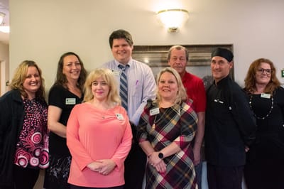 Staff members posing together in the facility lobby