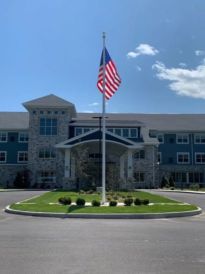 Exterior view of a senior living facility with an American flag
