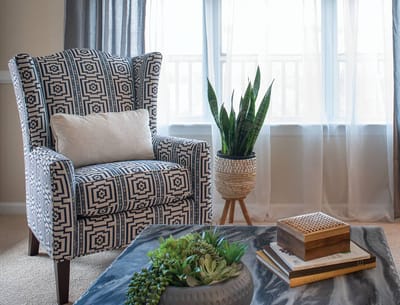 Cozy lounge area with patterned chair and plants