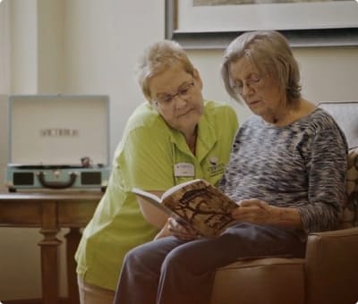 Care staff assisting a resident with reading