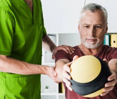 Staff assisting a resident with a therapy ball