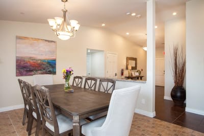 Bright dining area with a large table and flowers