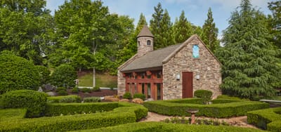 Stone chapel building surrounded by manicured gardens