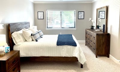 Bright and inviting resident bedroom with wooden furniture