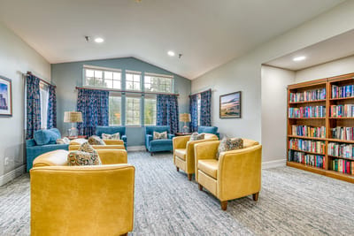 Bright common area with comfortable seating and bookshelves
