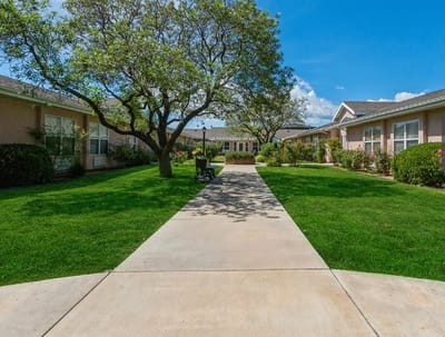 Pathway through a landscaped outdoor area of a senior living facility