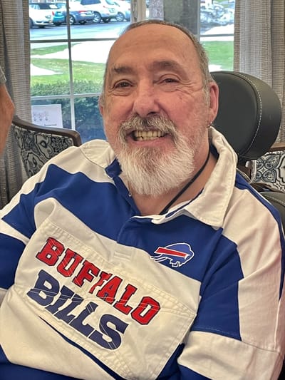Smiling resident in a blue shirt in a common area