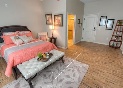 A well-decorated private room with a bed and seating area.