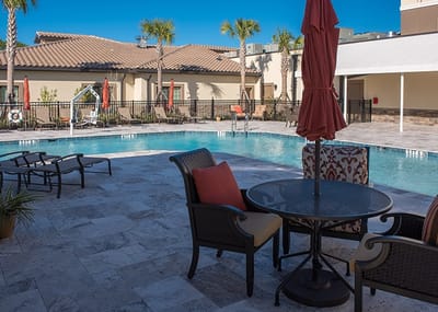 Outdoor pool area with seating and umbrellas