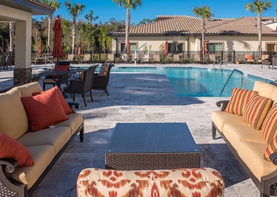 Outdoor pool area with seating and palm trees