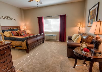 Cozy interior of a resident room with a bed and seating area
