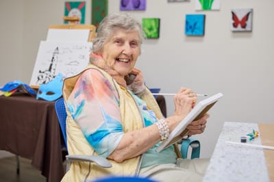 Resident painting in a bright activity room