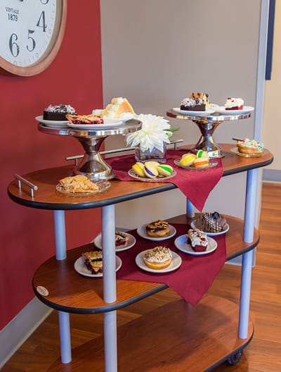 Dessert cart filled with various pastries in a dining area