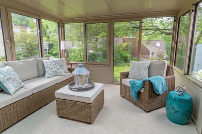 Bright sunroom with comfortable seating and garden view
