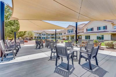 Outdoor seating area with shade and building in background