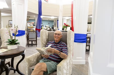 Resident enjoying a book in a cozy common area