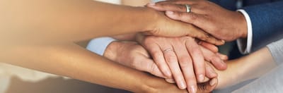 Multiple hands joined together symbolizing unity