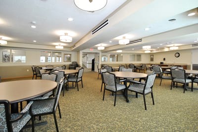 Common area with tables and chairs in a bright room