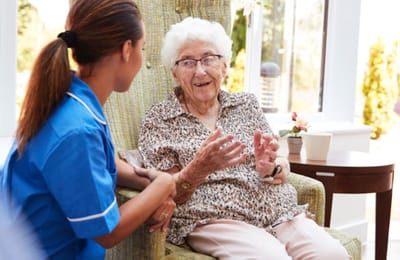 Staff member engaging with a resident in a cozy setting