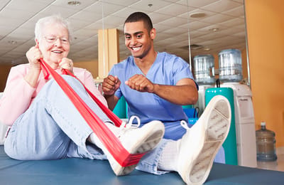 Resident and staff member engaging in therapy exercise