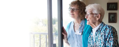 Staff member and resident looking out the window