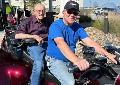 Two seniors riding together on a motorcycle trike
