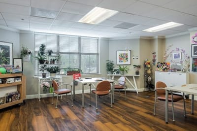 Bright common area with plants and tables.