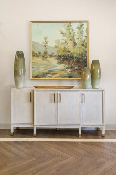 A decorated interior space with a cabinet and artwork