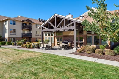 Exterior view of a senior living facility with outdoor seating