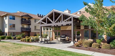 Exterior view of a senior living facility with outdoor seating