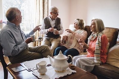 Residents enjoying tea and conversation in a cozy living area